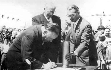 El presidente del gobierno Alemán, Sr. Dr. Eugen Gerstenmaier, firma el documento de la colocación de la primera piedra, a su lado el embajador de la República Federal de Alemania, Sr. Dr. Josef Fischer y el director, Sr. Ostr Werner Golde